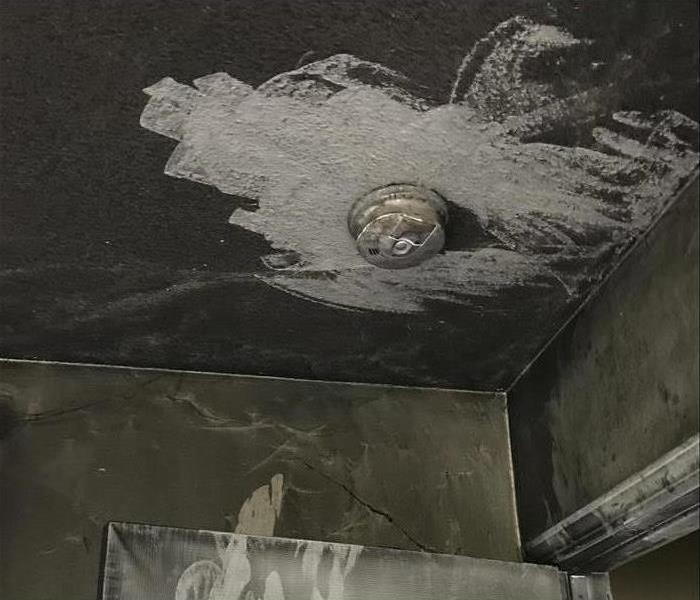 soot damage on the ceiling around a smoke alarm 