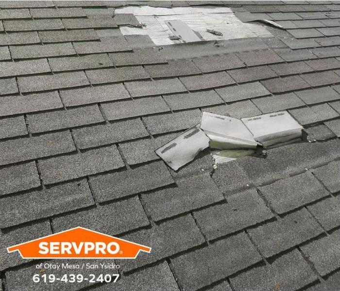 An asphalt roof is shown with missing roof shingles.