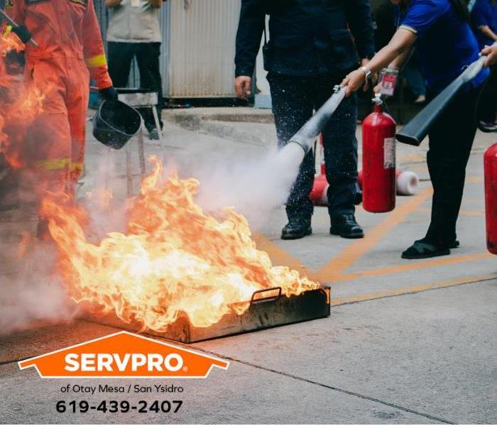 A community training program shows residents how to use a fire extinguisher to put out a fire.